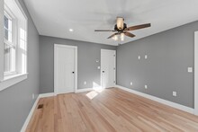 Interior View Of A Modern House Room With Gray Walls, A Wooden Floor And A Ceiling Fan