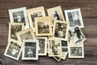 Vintage family photos wooden table background. Old pictures used paper