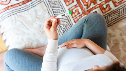 Pregnant headache fever sick. Pregnancy woman holding thermometer, check fever flu temperature. Pregnant girl sick. Pregnancy, medicine health care concept.