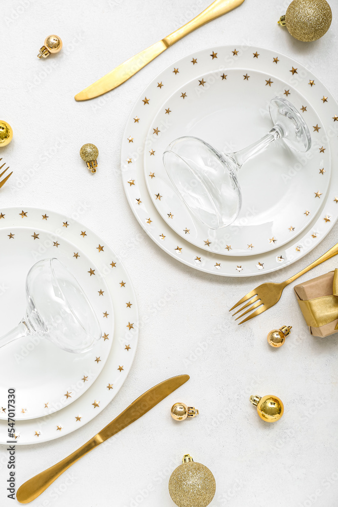 Beautiful table setting with golden Christmas balls on white background