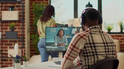 Poster - Young freelancer talking to coworkers on online videocall conference, attending remote business meeting on webcam at home. Using internet teleconference call to chat remotely at desk.
