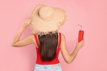 Sticker - Young woman in straw hat holding tin can with beverage on pink background, back view