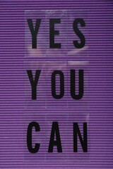 Wall Mural - Phrase Yes You Can of plastic letters on purple background, top view. Motivational quote