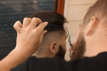 Sticker - Professional hairdresser working with client in barbershop, closeup