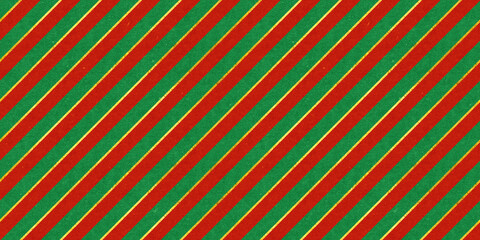Red and green vintage rough paper textured seamless diagonal candy stripes Christmas pattern with shiny gold foil decoration. Retro xmas card background, winter holiday backdrop or wrapping paper..
