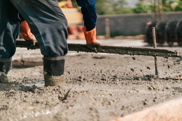 Wall Mural - Selective focus, Construction worker leveling concrete floor with trowel. Worker pouring concrete slab.