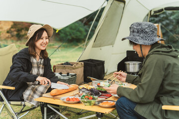 Sticker - 秋冬のキャンプ場で料理を作るアジア人のカップルキャンパー
