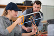 © auremar - a female plumber is cutting copper pipes