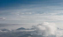 The Mountain Range Covered With Snow And Surrounded By Clouds. Winter Mountain Landscape.