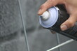 Closeup of man painting a fence with spray paint or aerosol paint