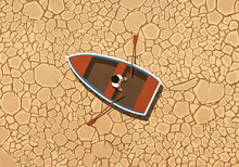 Man Sitting In Rowboat On Dry, Cracked Land
