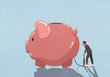 © fStop - Businessman inflating large piggy bank with bicycle pump