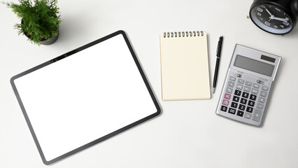 Wall Mural - Top view of modern office table with tablet empty screen, notebook, pen, calculator and alarm clock on white background