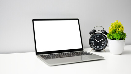 Wall Mural - Mock up laptop computer with empty screen and alarm clock on white table in office