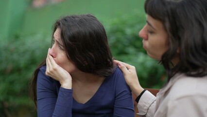 Wall Mural - Sad woman suffering from negative emotion. Two women embracing each other with EMPATHY