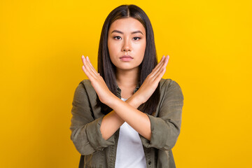 Portrait of serious gorgeous woman with long hairdo wear khaki shirt showings no stop gesture deny isolated on yellow color background