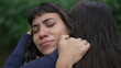 © Marco - A sad hispanic woman having the support of empathic friend. Two latin women hugging each other in community