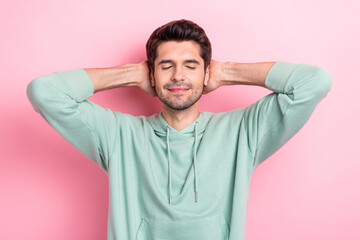 Wall Mural - Photo of peaceful glad young man closed eyes arms behind head take nap isolated on pink color background