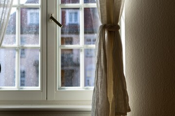 Closeup of a white dirty window with drapes