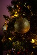 Vertical shot of a golden color Christmas ornament on a tree