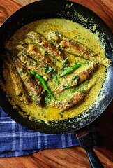 Poster - Vertical shot of tasty fish curry in a pan