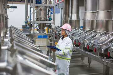 Wall Mural - Male worker inspection the process of food drink at the manufacturing vertical factory stainless.