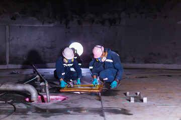 Wall Mural - Male worker inspection vacuum test bottom plate tank petrochemical steel weld leak