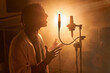 © ADDICTIVE STOCK - Black singer recording song in studio standing against glowing light