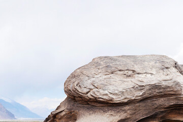 Wall Mural - cliff stone with mountain on clouds sky.