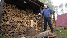 Bottom View Of Confused Man With A Log And A Sharp Vintage Axe Chop Wood For Fire Heat. Chopping Wood For The First Time.Preparation For Cold Wintertime. Alternative Fuel. Energy Crisis In Europe.