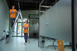 © Svitlana - Certified janitors holding tools near ladder and looking at camera