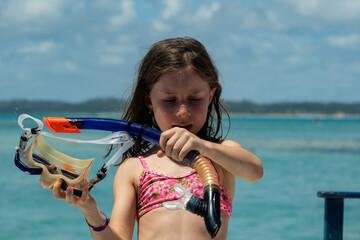 beautiful girl with snorkel in her hands with sea in the background