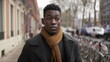 © Marco - Elegant young black man walking in sidewalk during winter season exploring city or commuting