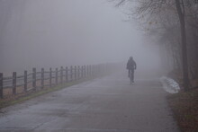 Cyclist In The Fog On A Trail