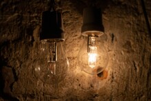 Closeup Shot Of Two Bare Light Bulbs On An Old Wall