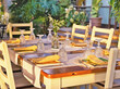© AkimaFutura - Covered wooden table in a southern ambience in the garden in the evening light