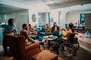 Businesswoman in wheelchair having business meeting with team at modern office. A group of young freelancers agree on new online business projects