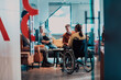 © .shock - Businesswoman in wheelchair having business meeting with team at modern office. A group of young freelancers agree on new online business projects