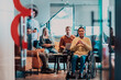 © .shock - Businesswoman in wheelchair having business meeting with team at modern office. A group of young freelancers agree on new online business projects