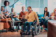 © .shock - Businesswoman in wheelchair having business meeting with team at modern office. A group of young freelancers agree on new online business projects