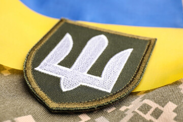military patch and ukrainian flag on pixel camouflage, closeup