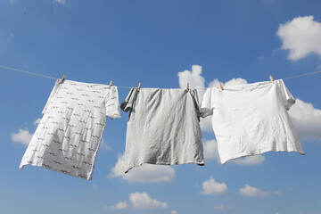 Washing line with clean clothes against sky. Drying laundry outside