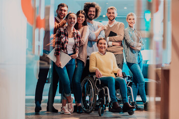 Wall Mural - Businesswoman in a wheelchair on break in a modern office with her team in the background