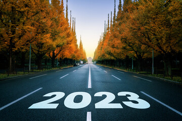 2023 New Year road trip travel and future vision concept . Nature landscape with highway road leading forward to happy new year celebration in the beginning of 2023 for fresh and successful start .