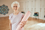 Fototapeta  - Yoga, mat and portrait of a senior woman in a wellness studio for an exercise or meditation class. Happy, smile and elderly female in retirement at mind and body pilates workout for peace and balance