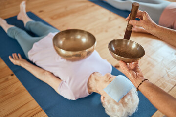 Canvas Print - Singing bowls, meditation and senior woman on floor for healing, vibration and sound therapy with healer. Sound healing, zen and elderly lady on a ground for tibetan bowl music, relax and wellness