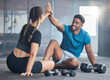 Fitness couple, high five and personal trainer with woman client to celebrate achievement, success and goal after exercise. Man and woman together at gym for partnership, health and wellness workout