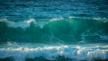 Large Powerful Jade Turquoise Colored Waves Crashing At Sennen Cove In Cornwall During Late Sunset
