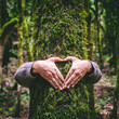 © simona - One man hugging a green tree trunk doing heart gesture with hands. People and love respect for nature forest and environment lifestyle. Environmentalist embrace trunk with musk. Stop climate change