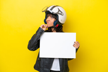 Wall Mural - Young latin woman with a motorcycle helmet isolated on yellow background holding an empty placard and thinking